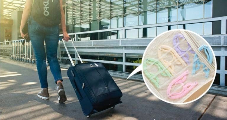 woman dragging suitcase and hangers inside