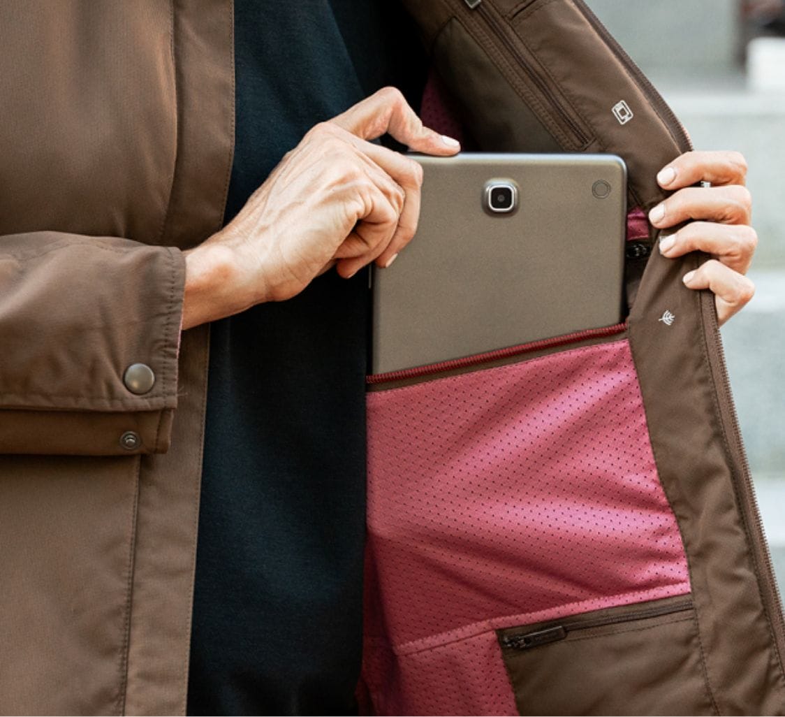 a person inserting gadget on the pocket of jacket