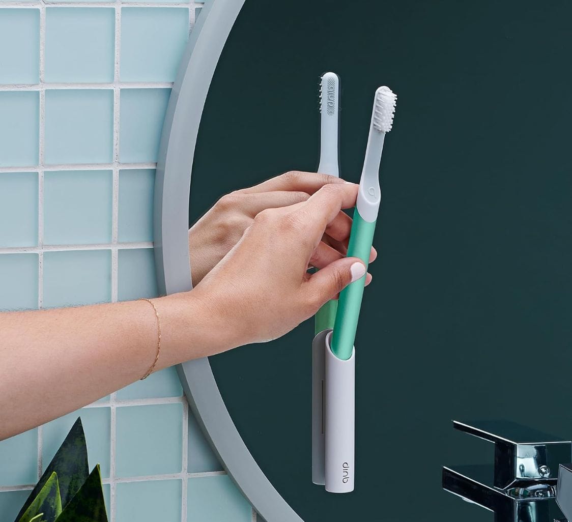 a person putting an electric toothbrush in a tube