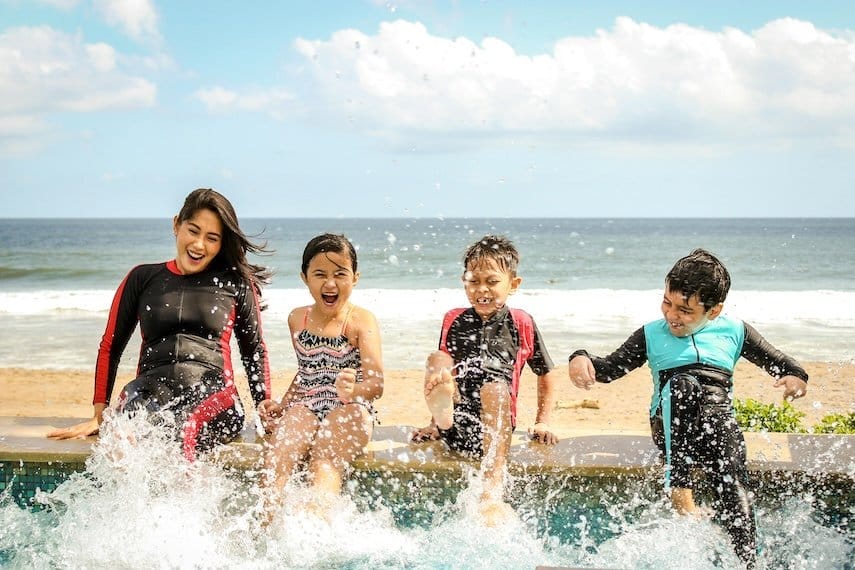 family of four splashing in a pool